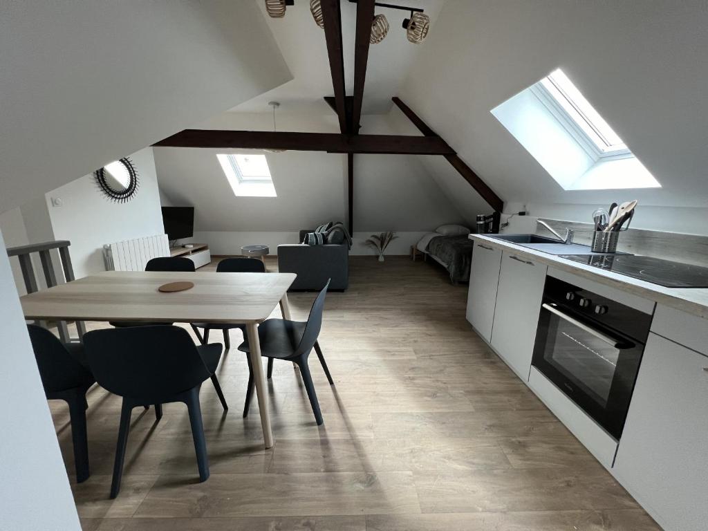 une cuisine et une salle à manger avec une table et des chaises dans l'établissement Sous les Toits - Appart Familial 5p, Centre-ville, à Boulogne-sur-Mer