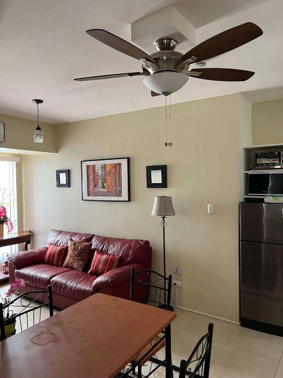 a living room with a couch and a ceiling fan at Belle's Staycation in Cebu City