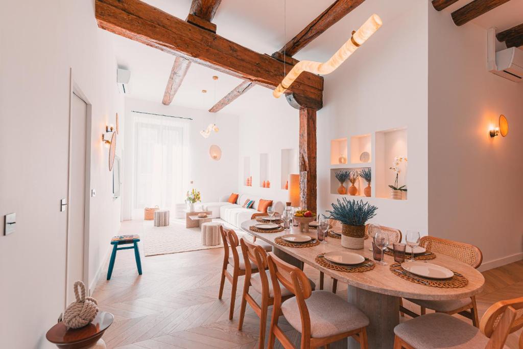 un salon avec une grande table et des chaises dans l'établissement Prestigieux T6 au Vieux Port by Maison Galante, à Marseille