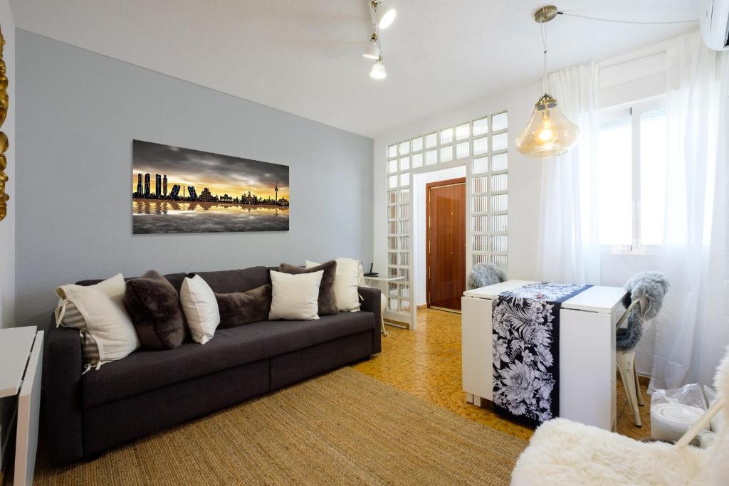 een woonkamer met een bank en een tafel bij My City Home - Acogedor apartamento en Aravaca in Madrid