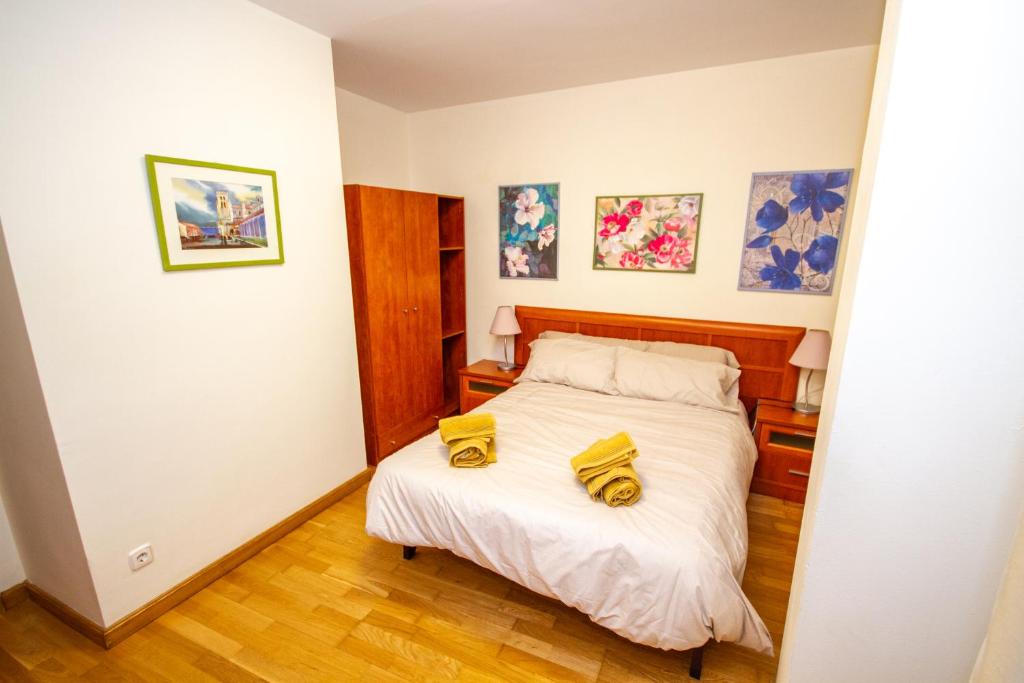 a bedroom with a bed with yellow shoes on it at MAGIC I a 1 minuto de la Catedral y Plaza Mayor in León