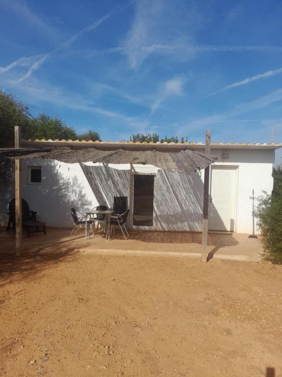 een huis met een tafel en stoelen ervoor bij Bungalow en finca de campo in Islas Baleares
