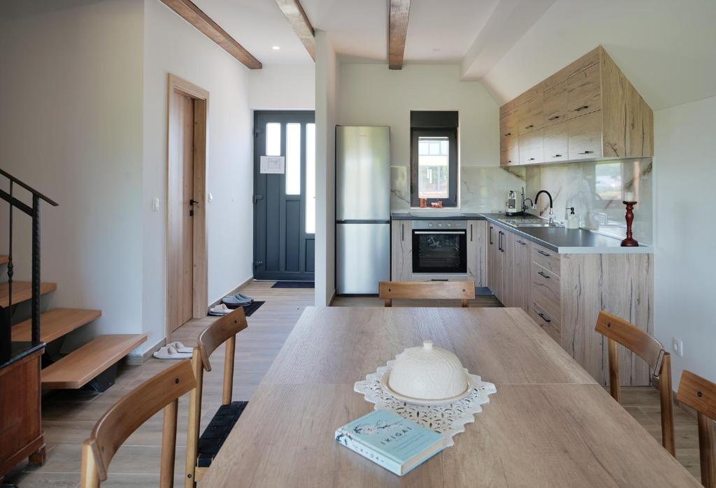 a kitchen with a wooden table and a kitchen with a refrigerator at Green River Retreat House in Brodani