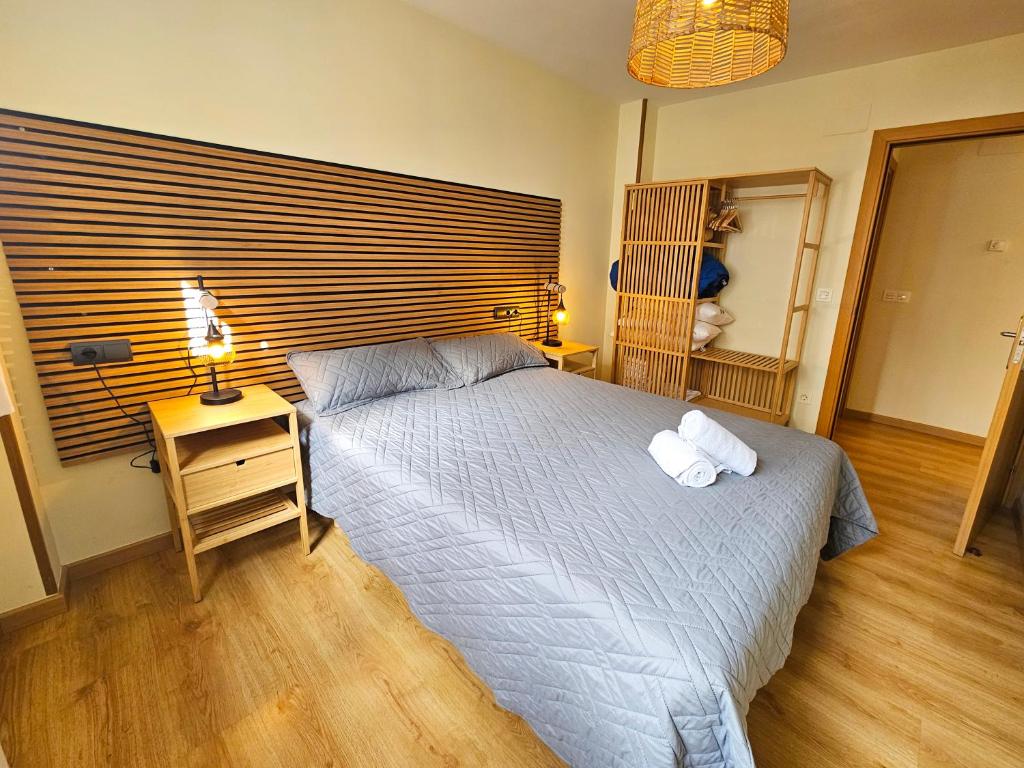 a bedroom with a bed with two towels on it at Apartamentos Escarrilla Suites 3000 in Escarrilla
