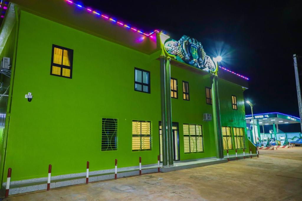 ein grünes Gebäude mit seitlicher Beleuchtung in der Unterkunft United Hotel Balessing in Balessing