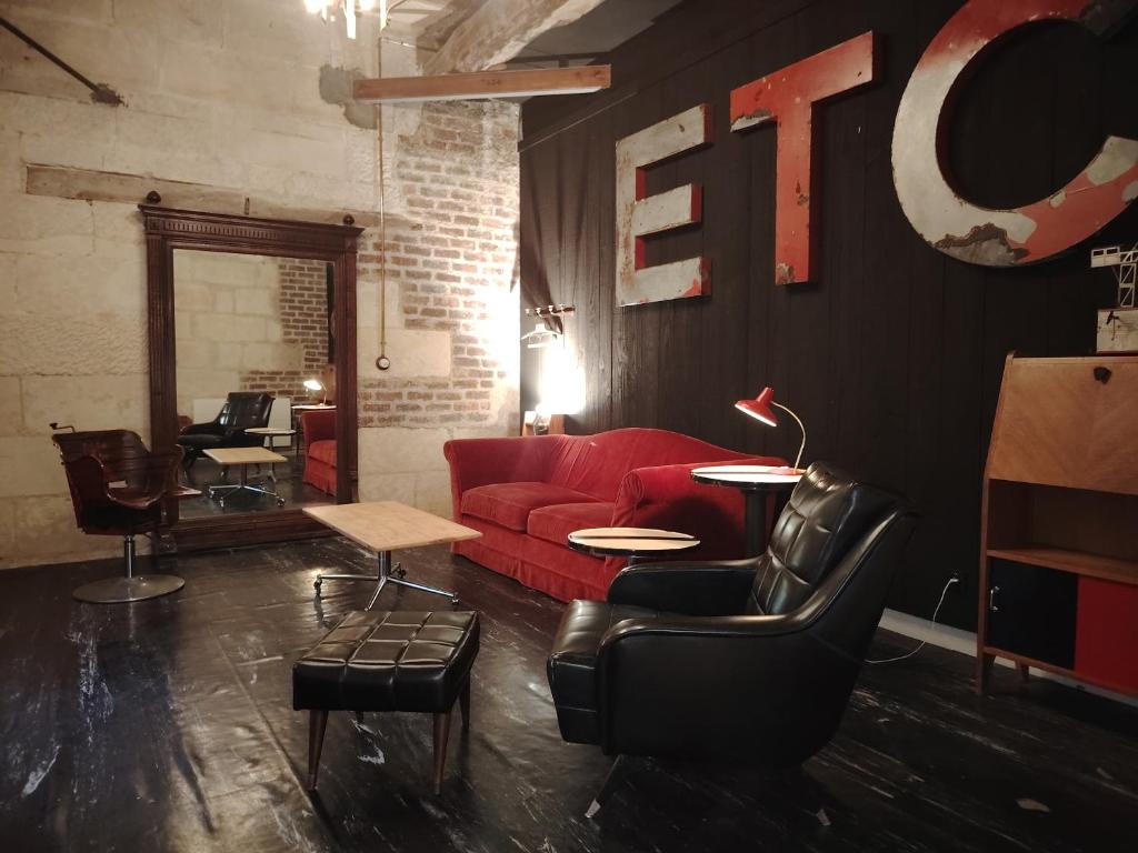 a living room with a red couch and a red chair at La Belle Étoile in La Chartre-sur-le-Loir