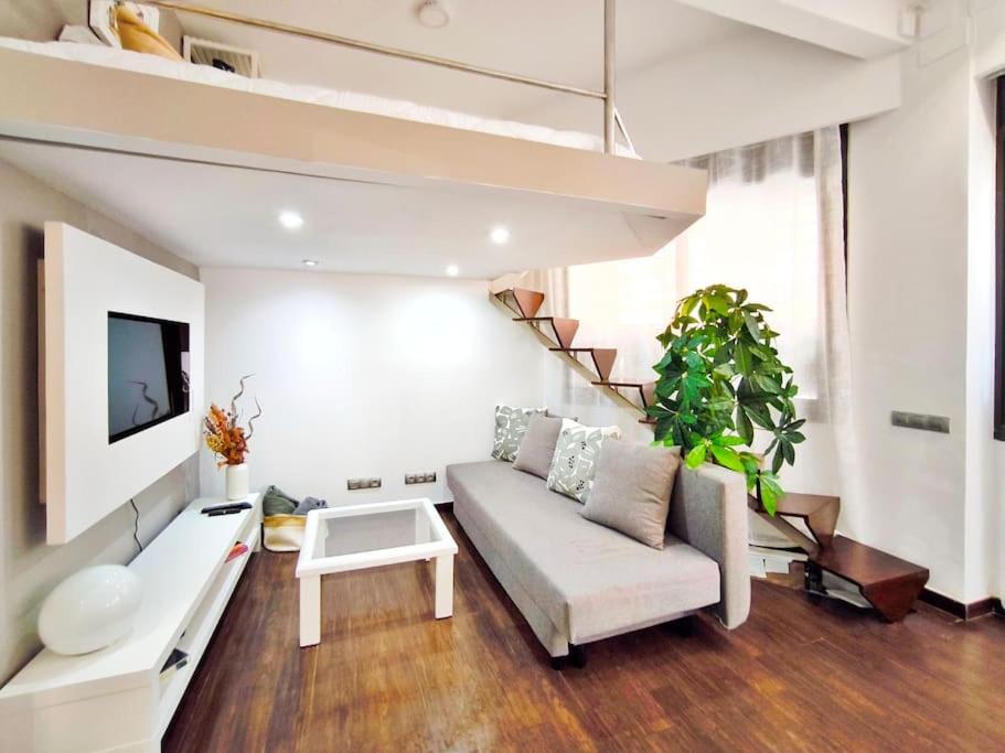Una sala de estar con un sofá y una escalera. en Apartamento en Terrassa en alquiler vacacional, en Terrassa