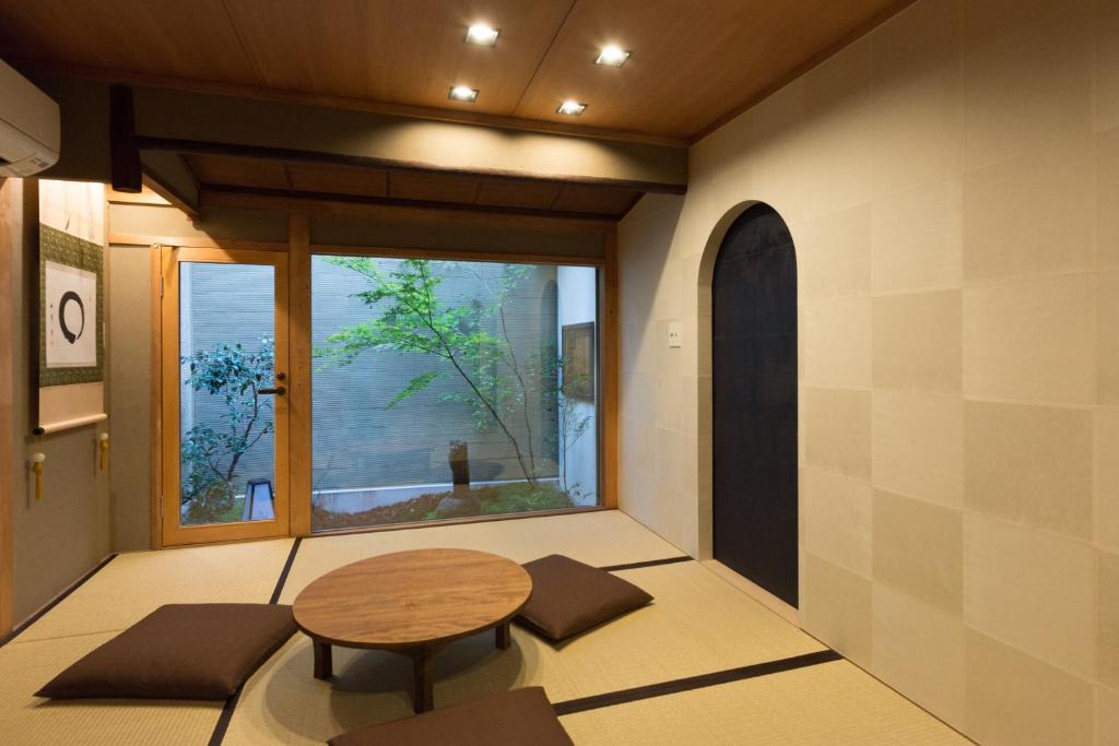 een kamer met een tafel en een groot raam bij Kakishibu an Machiya House in Kyoto