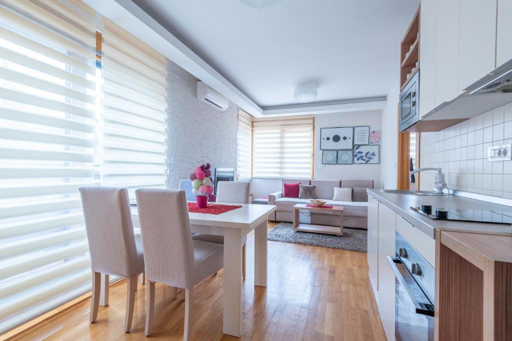 eine Küche und ein Wohnzimmer mit Tisch und Stühlen in der Unterkunft Konačište Egoiste - Centar in Zlatibor