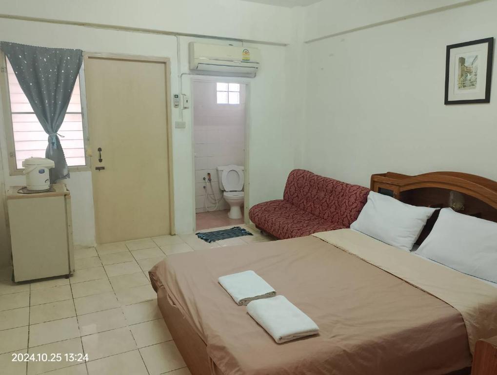 a bedroom with a large bed and a couch at Nakara Place บ้าน นาครา in Ban Rang Pho