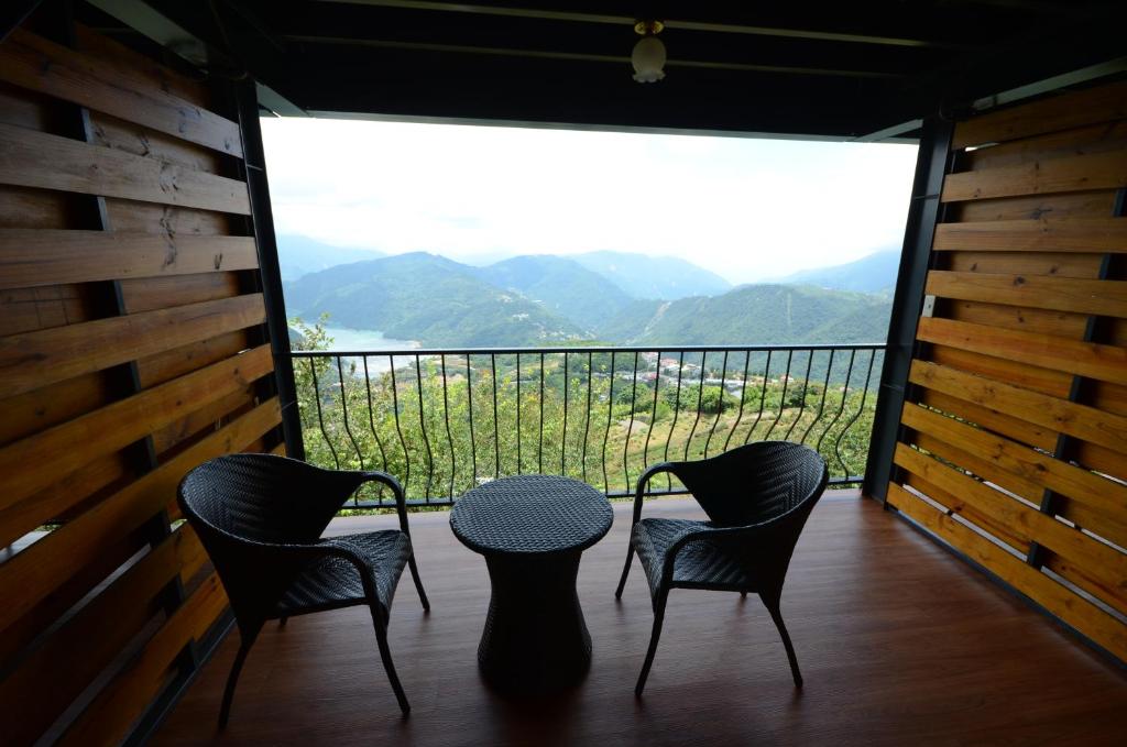 a table and four chairs on a balcony with a view at Cingjing Four Seasons B&amp;B in Ren&#39;ai