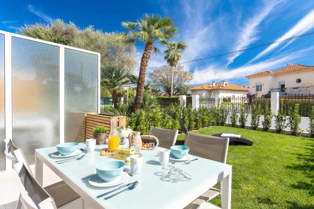 a white table and chairs in a yard at Villa Velvet in Villeneuve-Loubet