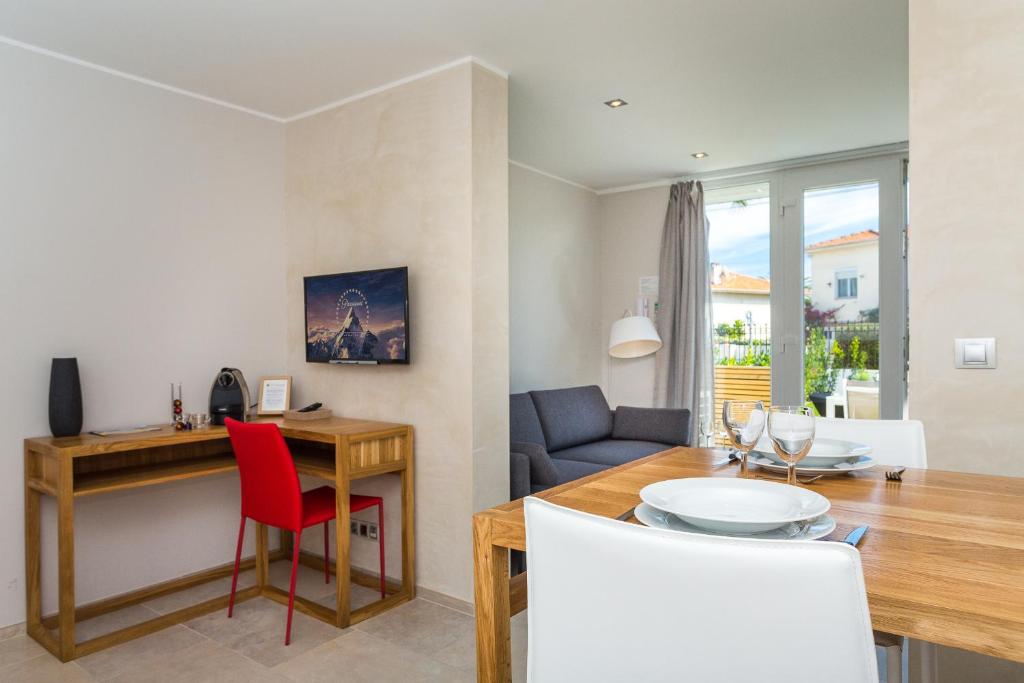 a dining room and living room with a table and chairs at Villa Velvet in Villeneuve-Loubet
