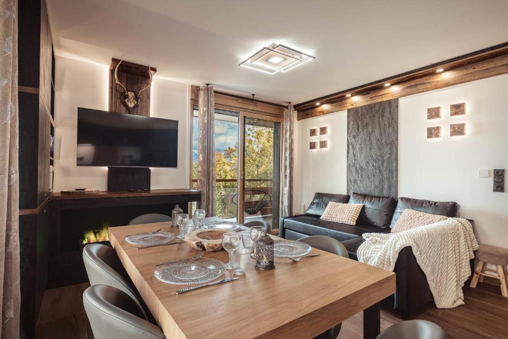 un salon avec une table et un canapé dans l'établissement Apartment Nid des Neiges - Perfect for families, à Combloux