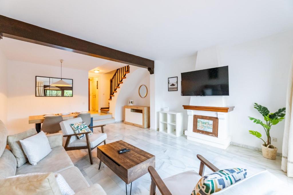 een woonkamer met een bank en een open haard bij Casa Jardines del Sol 4 in Marbella