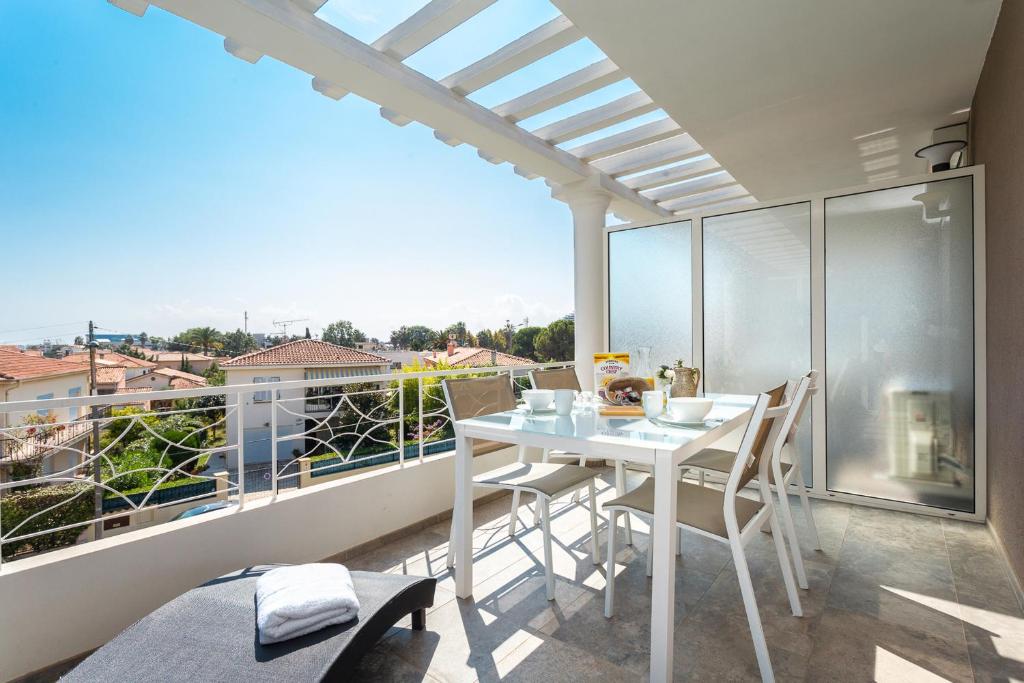 a balcony with a table and chairs and a view at Villa Velvet in Villeneuve-Loubet