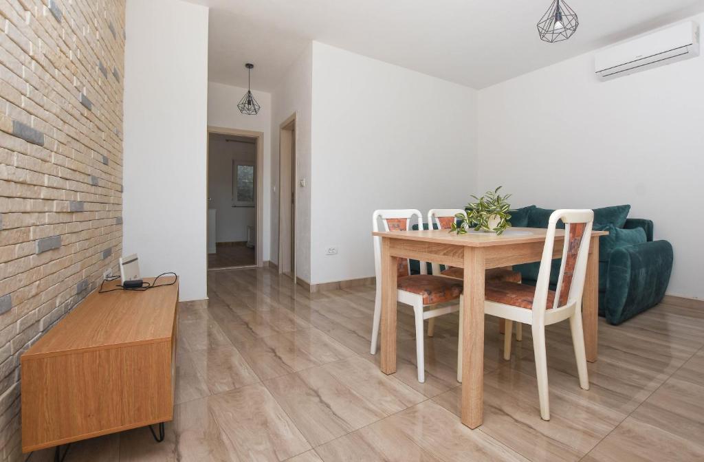 a dining room with a table and chairs and a couch at Relax 1 in Pakoštane
