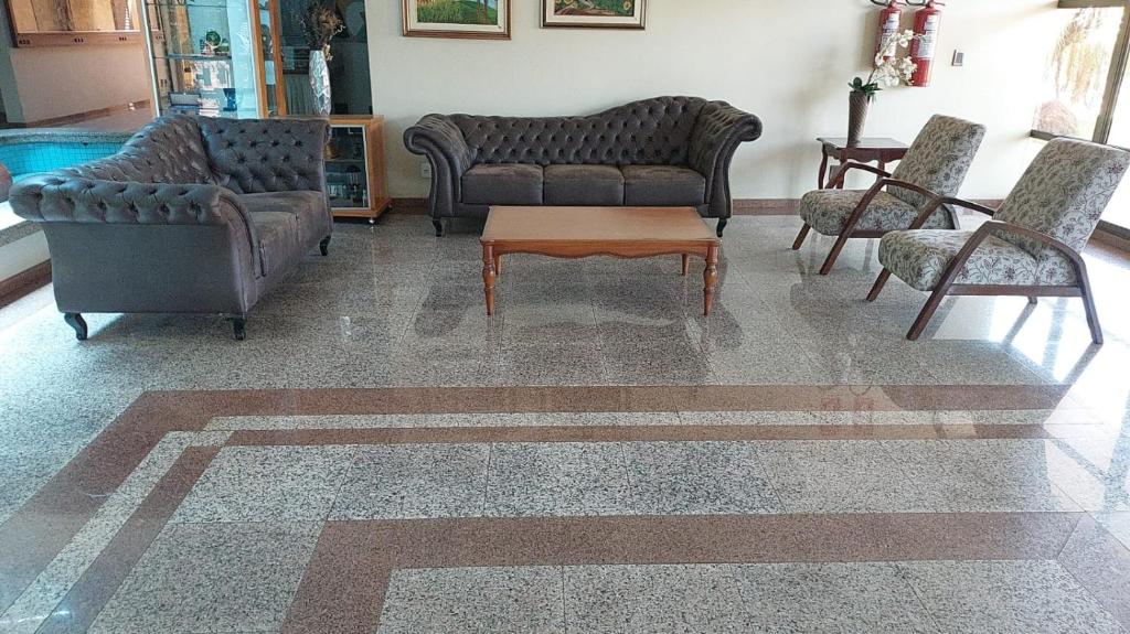 a living room with couches and a table and chairs at Pousada dos Girassóis in Palmas