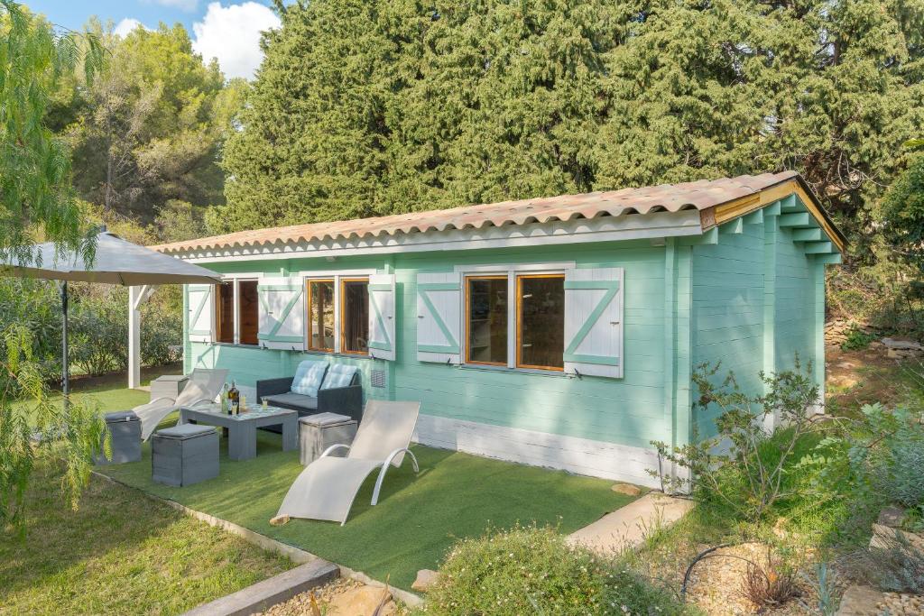 une petite maison bleue dans un jardin dans l'établissement Le Colibri, à La Ciotat
