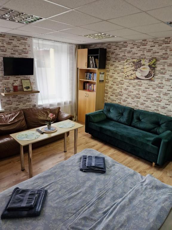 a living room with a green couch and a table at Apartament Erfolg 11 in Daugavpils