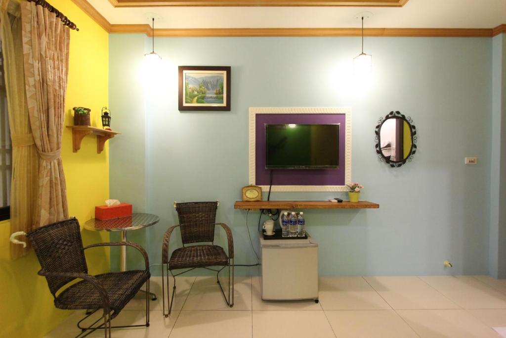 a living room with a tv and a table and chairs at Kenting Diack Inn in Hengchun South Gate