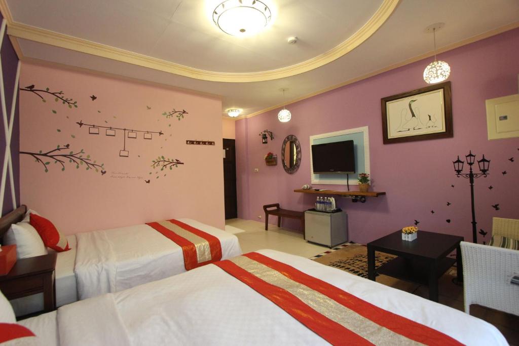 a hotel room with two beds and a tv at Kenting Diack Inn in Hengchun South Gate