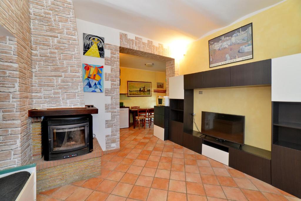 Una sala de estar con chimenea y televisión. en Villa Agello con Idromassaggio, en Agello