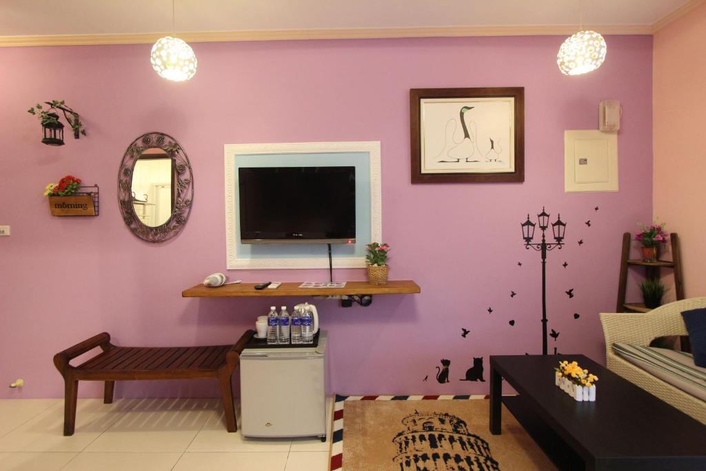 a living room with a tv on a purple wall at Kenting Diack Inn in Hengchun South Gate