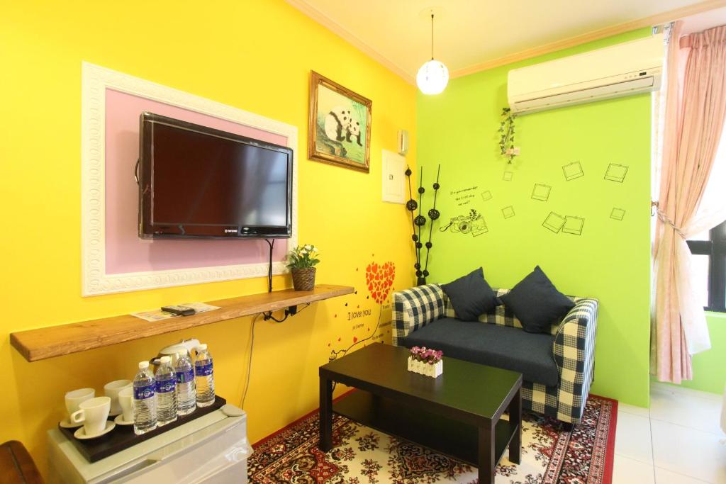 a living room with a couch and a flat screen tv at Kenting Diack Inn in Hengchun South Gate
