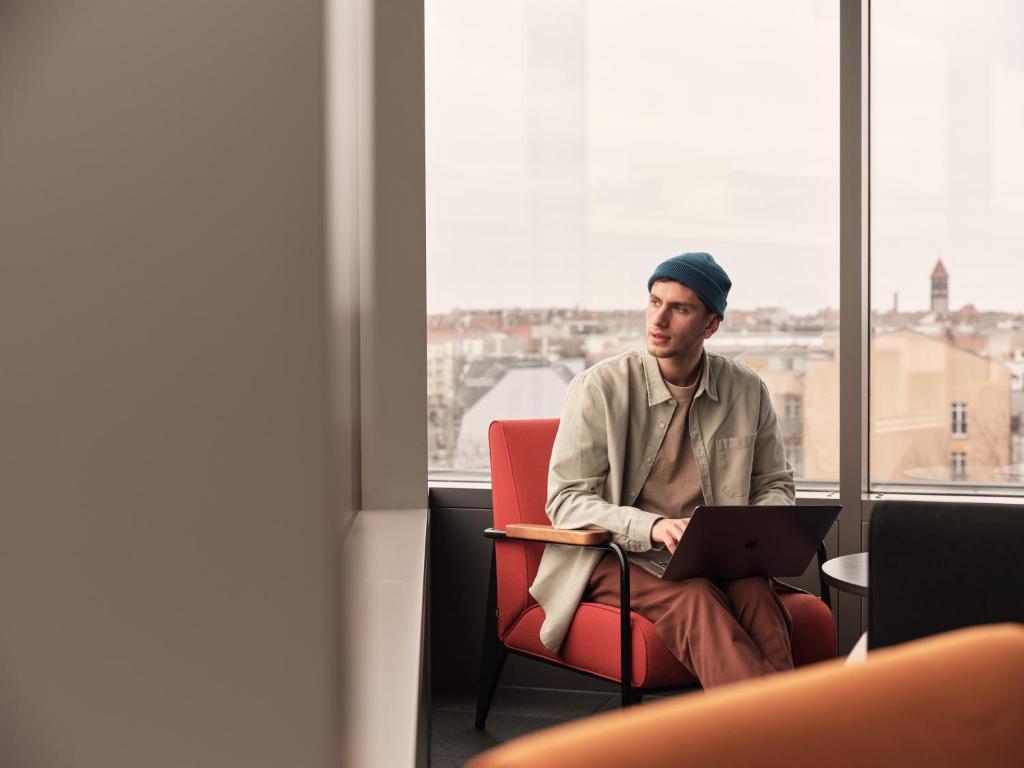 a man sitting in a chair with a laptop at Casa Camper Berlin in Berlin