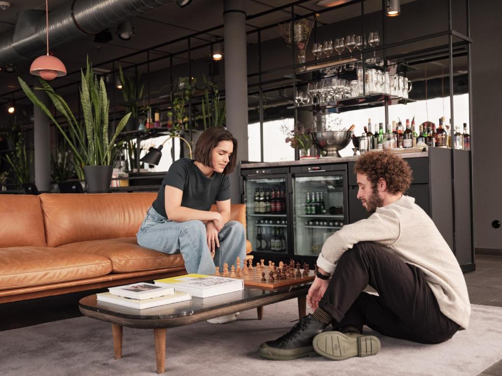 a man and a woman playing chess in a living room at Casa Camper Berlin in Berlin