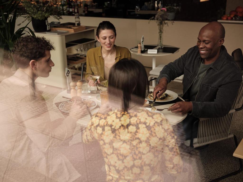 a group of people sitting around a table eating food at Casa Camper Berlin in Berlin
