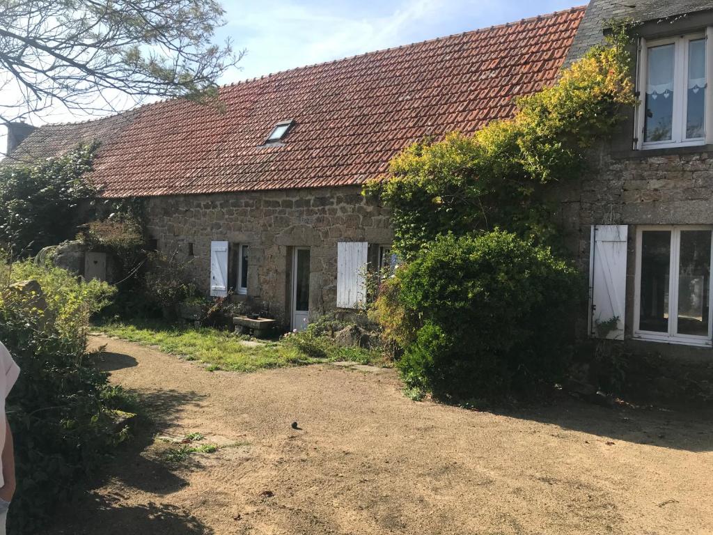 une ancienne maison en pierre avec un toit rouge dans l'établissement La route du phare, à Fermanville
