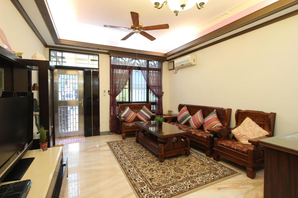 a living room with couches and a ceiling fan at Kenting Diack Inn in Hengchun