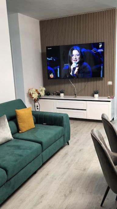 a living room with a green couch and a flat screen tv at cris residence in Alba Iulia