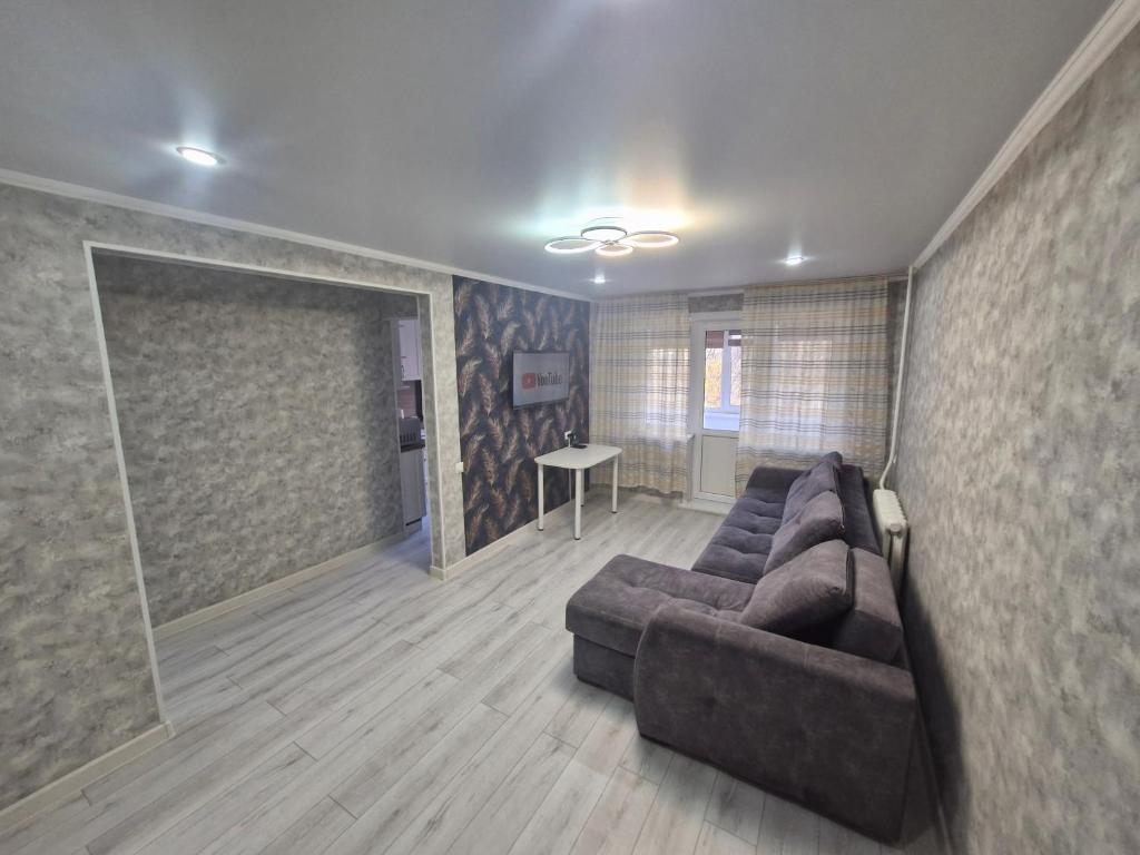 a living room with a couch and a table at 1-ком апартаменты Comfort Plus Elita in Petropavlovsk