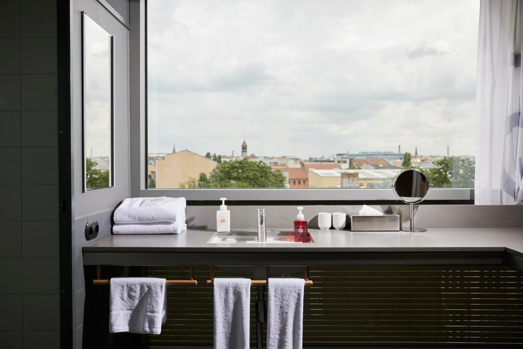 a bathroom with a sink and a window with towels at Casa Camper Berlin in Berlin