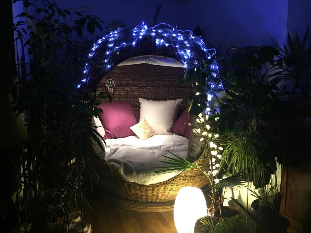 - un lit en osier avec des lumières bleues dans l'établissement Exotic Loft in Montmartre + terrace !, à Paris