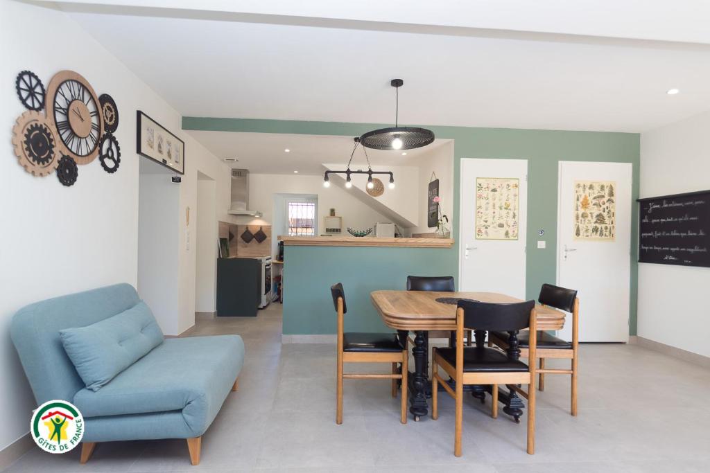 a dining room and kitchen with a table and chairs at Gîte des Mouliniers in Saint-Siméon-de-Bressieux