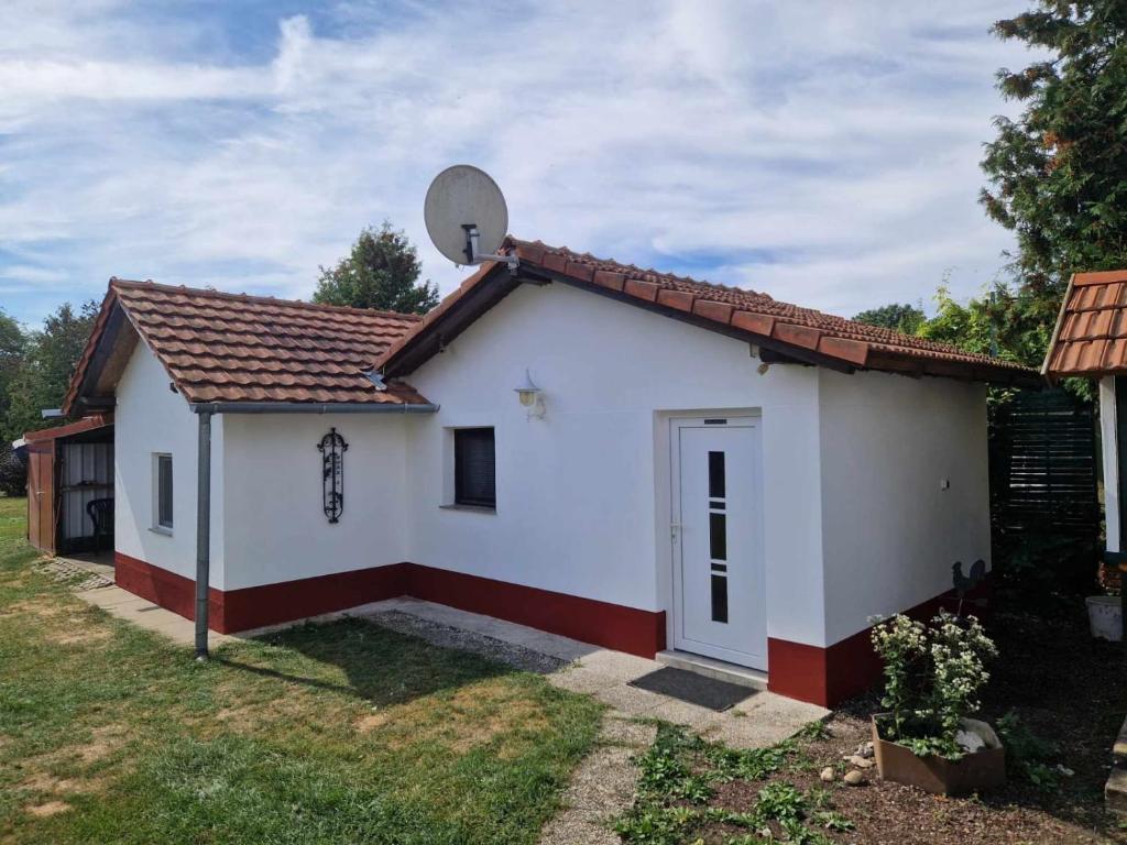 a small white house with a satellite at Jäger-Lodge in Lócs