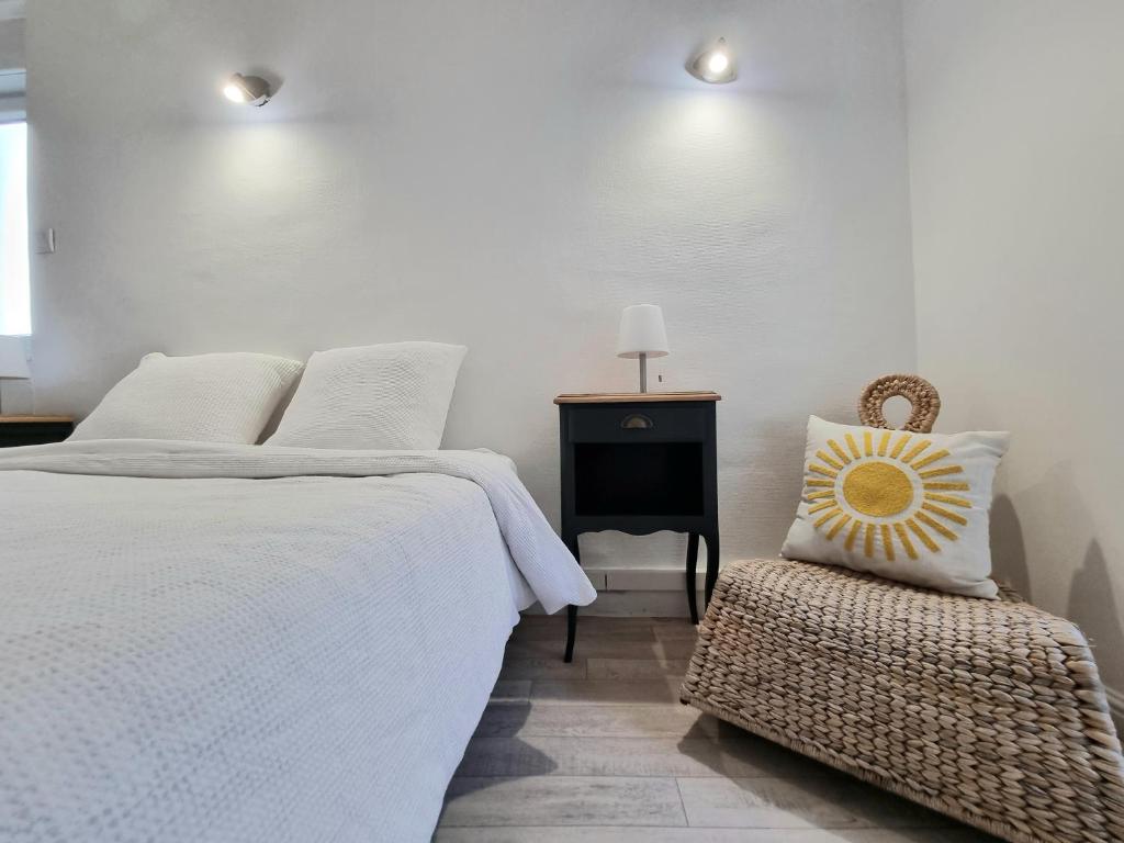 una camera da letto bianca con un letto e una sedia di La Chambre Bleue - Chambre avec salle de bain ad Argenton-sur-Creuse