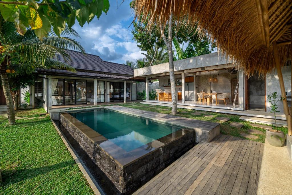 an infinity pool in the backyard of a house at Sola Villa Ubud in Ubud