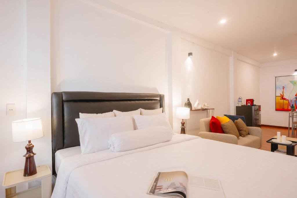 une chambre avec un lit blanc avec un livre dessus dans l'établissement CBD Studio3 next to Sun Plaza Real City Center!, à Medan