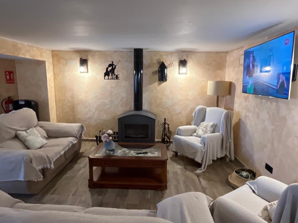 un soggiorno con divani bianchi e camino di El Cortijo de Vega a Alhambra