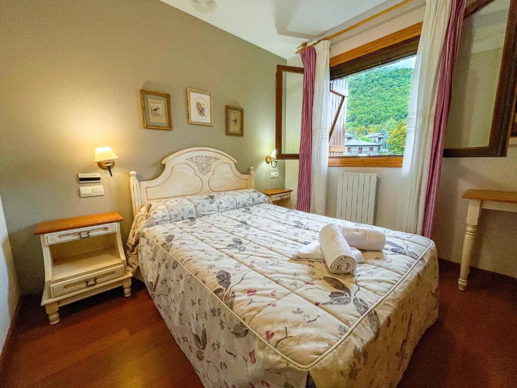 a bedroom with a large bed and a window at Apartamentos Gavín Biescas 3000 in Gavín