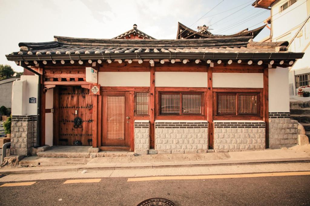 ein asiatisches Gebäude mit Holztüren auf einer Straße in der Unterkunft Bukchonmaru Hanok Guesthouse in Seoul