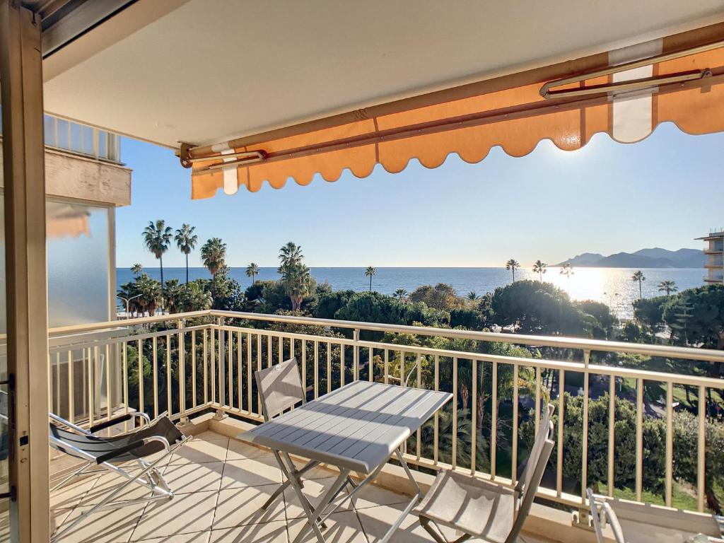 un patio avec une table et des chaises sur un balcon dans l'établissement Superbe vue mer terrasse - 218L MISS, à Cannes