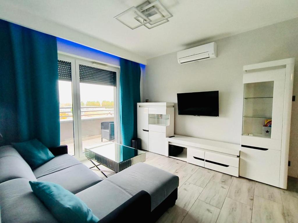 Una sala de estar con un sofá y un televisor. en Apartament LOFT, en Gorzów Wielkopolski