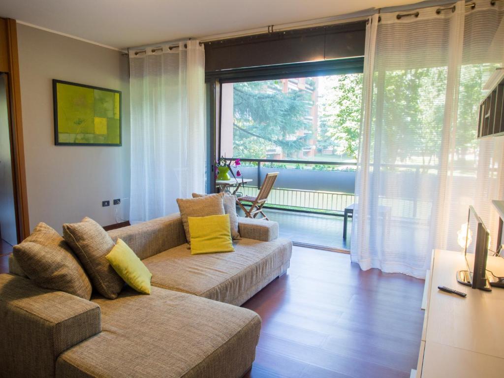 a living room with a couch and a large window at Casa vacanze Tigli in Basiglio