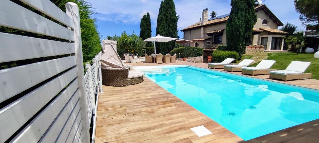 a swimming pool in a backyard with a white fence at Villa Tagliaferri by PosarelliVillas in Vasto